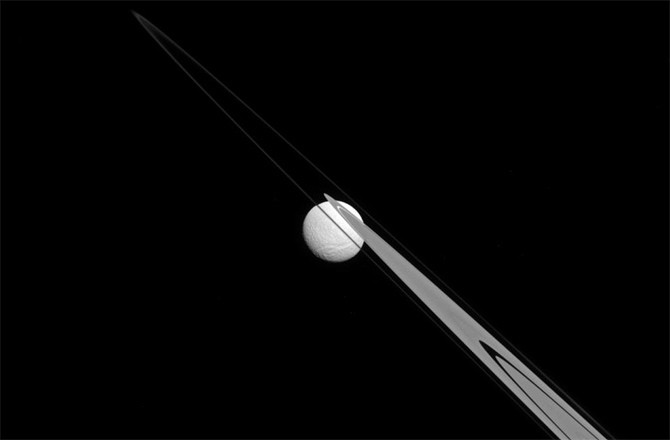 İşte, Satürn'ün dikine düşen halkalarından sadece birkaç km uzaklıkta, uçurumun kenarında öylesine unutulmayı bekler gibi görünen Tethys.